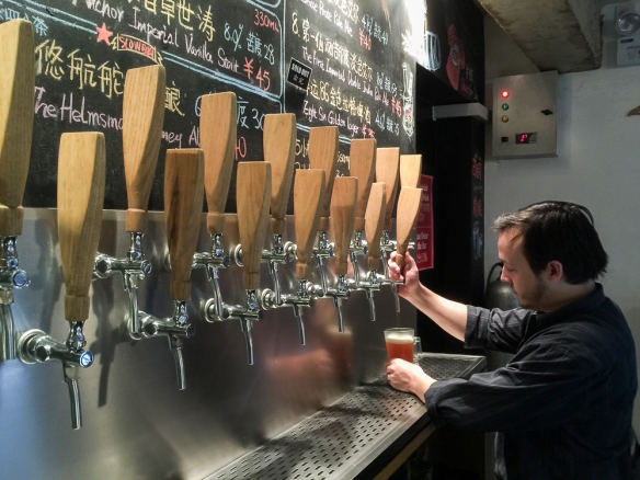 Pouring a pint of draught beer at Slow Boat Brewery in Beijing.